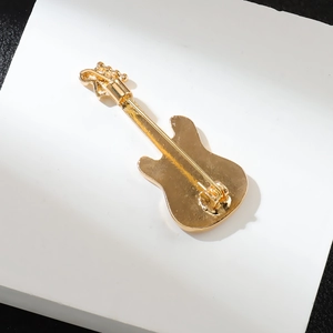 Vue arrière détaillée d'une broche guitare dorée avec fermoir en alliage de zinc durable
