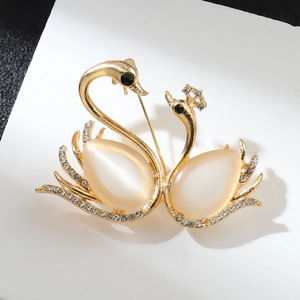 Elegant gold-tone swan brooch with cat-eye stones and white rhinestones for suits