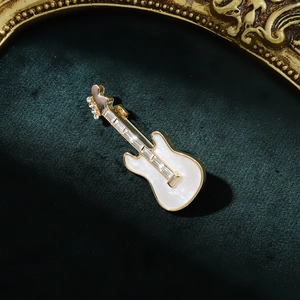 Élégante broche guitare électrique dorée avec émail blanc et strass scintillants