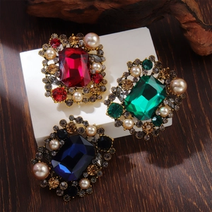 Vintage style alloy brooches with pearls, emerald and ruby gems on a geometric platform