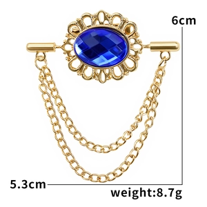 Detail of vintage gold brooch with blue oval gemstone and tassels showing 6cm x 5.3cm size
