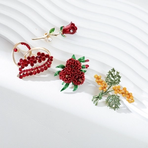Elegante Broschen mit roten Rosen und Herz-Strasssteinen auf weißer Strukturtafel