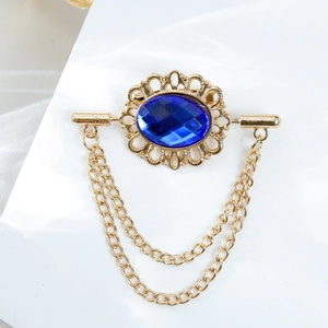Vintage gold brooch with large blue oval gemstone and elegant tassel chains on white