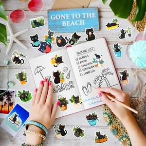Set of 50 cute black cat doodle stickers for laptops and DIY decoration on a bright desk