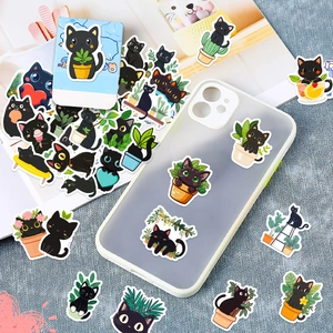 DIY cartoon black cat stickers applied on a transparent phone case and magazine deco