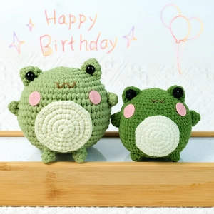 Handmade crochet frog plush set in wood tray with Happy Birthday background