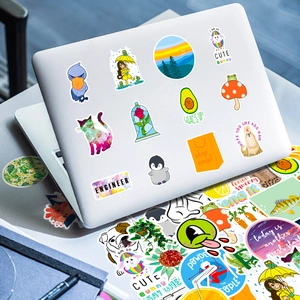 Close-up of vibrant orange and animal stickers applied on a laptop shell for decoration