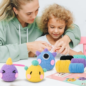 DIY crochet kit for three monsters including colorful yarn balls, hooks, and instructions