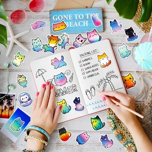 Detailed view of cat graffiti stickers on an open planner in a summer holiday setting