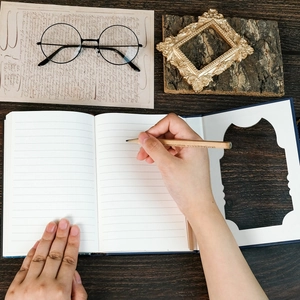 Macro view of blue hardcover journal with lined pages and wood pencil on vintage desk