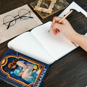 Aquarius theme notebook with goddess illustration and magnetic clasp on wooden desk