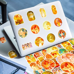 Vintage Alphonse Mucha Art Nouveau stickers on a silver laptop with floral patterns
