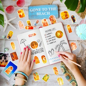 Flat lay of vintage Mucha art stickers on a summer beach themed desk setup with stationery