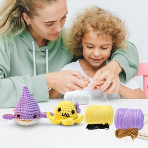 Gros plan du kit de crochet DIY comprenant du fil coloré et des poupées requin et poulpe finies