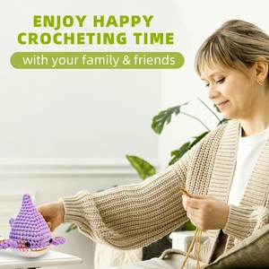 Détail d'une main tenant un requin en crochet violet fini issu du kit de tricot DIY