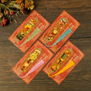 Set of four vintage metal bookmarks with colorful tassels on a rustic wood background