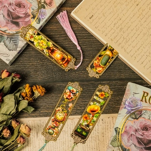 Set of four vintage hollow metal bookmarks with colorful art illustrations and tassels