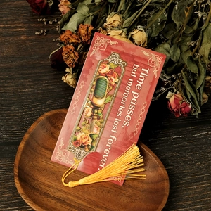 Detail of red vintage bookmark with rose illustration, golden tassel, and dried flowers