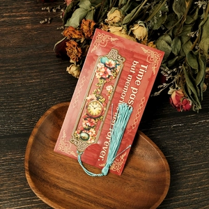 Detail of vintage hollow metal bookmark with blue tassel on a classic red card