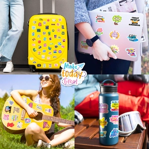Inspirational stickers with motivational quotes on a laptop, suitcase and guitar