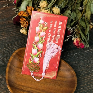 Detailed view of hollow metal tulip bookmark with pink silk tassel on a gift card