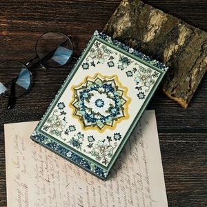 Vintage mandala patterned journal notebook with magnetic clasp on a dark wooden background