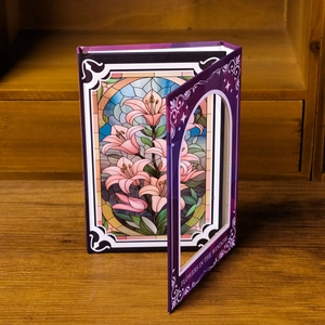 Nahaufnahme Notizbuch mit Blumenmuster, Fenster-Ausschnitt und rosa Lilien-Motiv