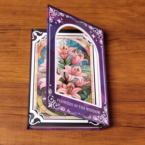 Violetter Notizblock mit Buntglas-Lilien-Design und Flowers in the Window Aufdruck