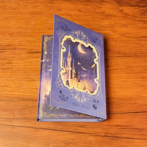 Purple Magic Castle hardcover notebook with hollowed-out cover on a wooden desk