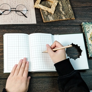 Retro green hardcover notebook with grid pages, wooden pencil, and vintage desktop decor