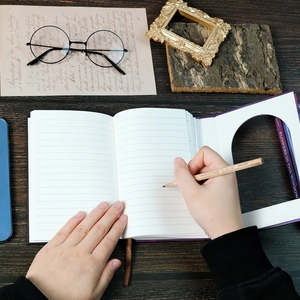 Flat Lay eines lila gebundenen Notizbuchs mit linierten Seiten und Holzbleistift