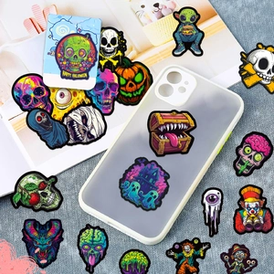 Nahaufnahme wasserfester Totenkopf- und Halloween-Aufkleber auf einer klaren Handyhülle