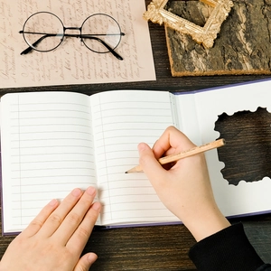 Flat lay of purple castle notebook with a wooden pencil and vintage stationery aesthetic