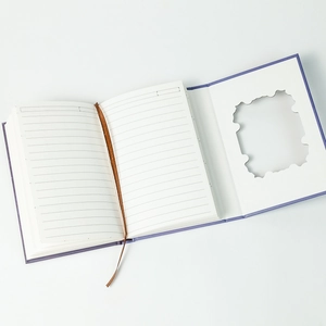 Detail view of purple hardcover notebook with ribbon bookmark and hollow inner window