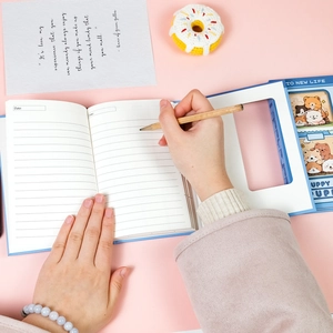 Detail of light blue cartoon notebook with hollow window design and lined inner pages