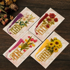 Detail von vier Metall-Lesezeichen mit Quasten und filigranem floralen Hohldesign