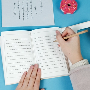 Flat lay of dotted cream paper pages for vintage cat notebook on blue background