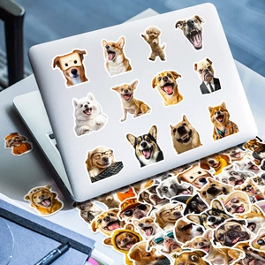 Macro shot of waterproof dog stickers on a laptop with diverse funny puppy designs
