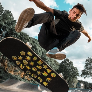 Close-up of golden laser Christmas stickers with holographic glitter on a skateboard deck