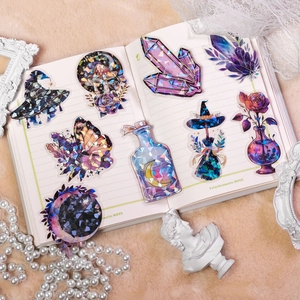 Detail of holographic fairy tale stickers with butterfly and crystal patterns on a notebook