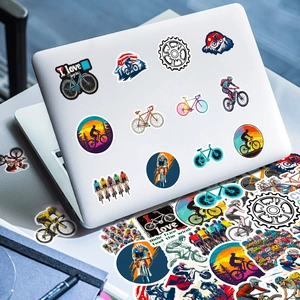 Pegatinas impermeables de ciclismo de montaña en una laptop plateada y mesa