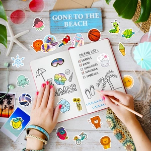 Flat lay of colorful waterproof summer stickers on a wooden desk with beach props