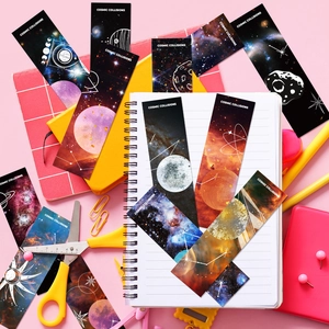 Lot de marque-pages Cosmic Collisions avec motifs de galaxies et planètes sur bureau