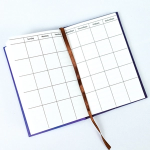 Detail of purple notebook inner pages featuring monthly calendar grid and silk bookmark