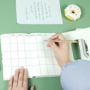 Close-up of three-fold notebook showing weekly planner layout and hollow design