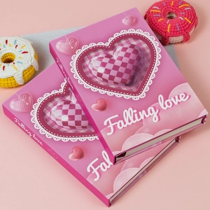 Detailed close-up of pink heart-themed notebook with Falling love text and lace decoration