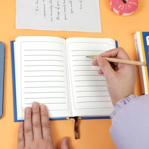 Detail of creative blue notebook with dot grid pages and a brown ribbon bookmark