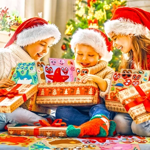 Children at a Christmas tree opening DIY ocean animal face sticker gift packs