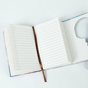 Close-up of floral notebook with lined pages, silk ribbon bookmark and hollow gift box