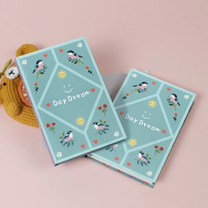 A pair of Day Dream series graffiti notebooks with bird and rose illustrations